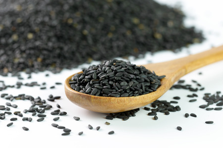 Heap of black sesame on wooden spoonの写真素材