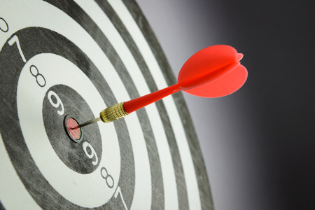Meet target concept using dart pinned at the bullseye of dartboard