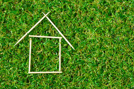 Model house made with toothpick on green grassの写真素材