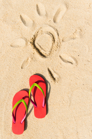 Summer theme with red flip flop on sandy beachの写真素材