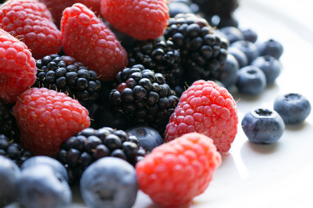 Fresh ripe blackberries, raspberries and blueberries on white backgroundの写真素材