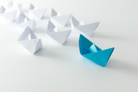 Leadership concept using blue paper ship among whiteの写真素材