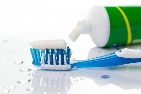 Close up of blue toothbrush and toothpaste tube