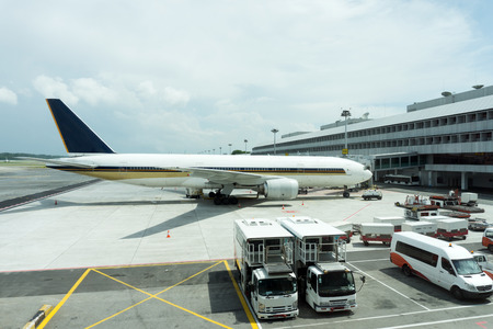 Truck refuelling airplane at airport, picture taken through window