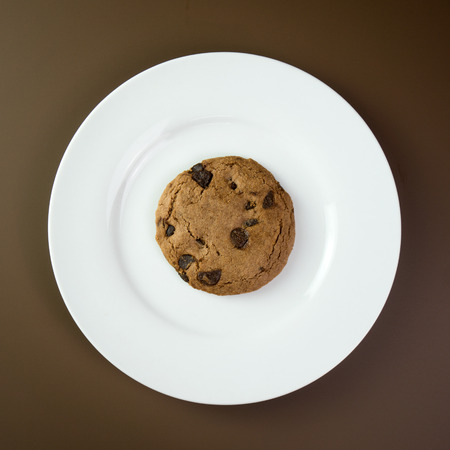Close up of chocolate chip cookie on white plateの写真素材