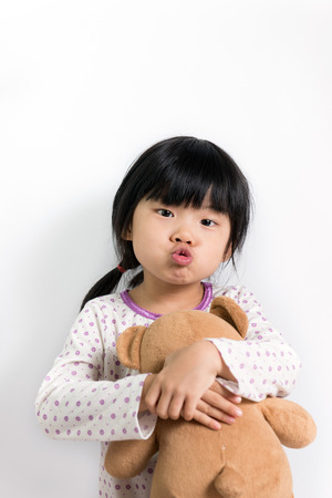 Little child in pyjamas holding teddy bearの写真素材