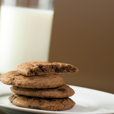 Stack of chocolate chips cookies served with milkの写真素材