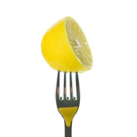 Half lemon on fork over white backgroundの写真素材