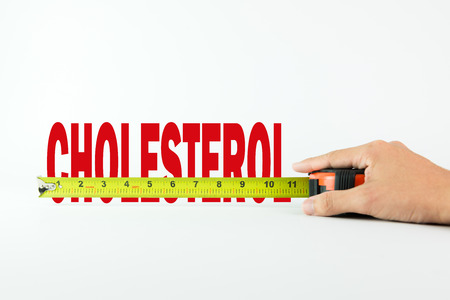 Measure the word cholesterol with measuring tape on white backgroundの写真素材