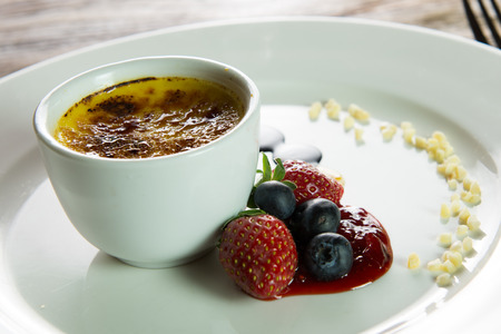 Italian dessert creme brulee served with berriesの写真素材