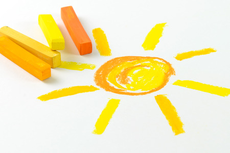 Child drawing of sun using oil pastel crayonの写真素材