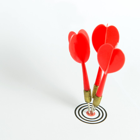 Three red darts pinned right on the center of dartboardの写真素材
