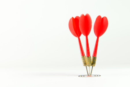 Three red darts pinned right on the center of dartboardの写真素材