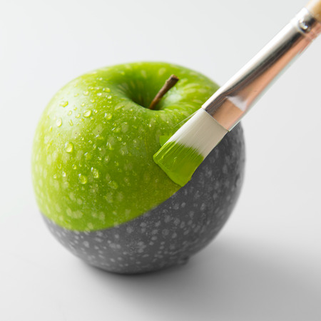 Painting a fresh green apple with paintbrushの写真素材