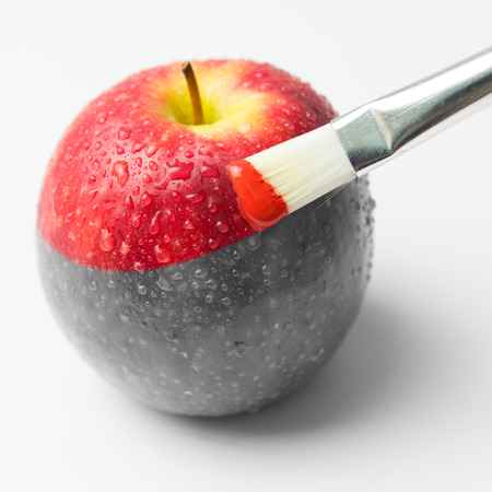 Painting a fresh red apple with paintbrushの写真素材