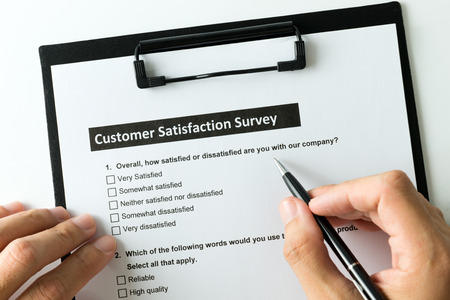 Filling customer satisfactory survey form with penの写真素材