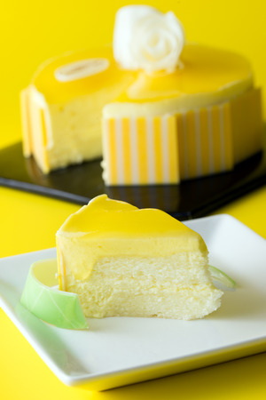 Slice of mango mousse cake served on white plateの写真素材