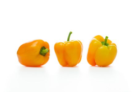 Three yellow capsicums isolated on white backgroundの写真素材