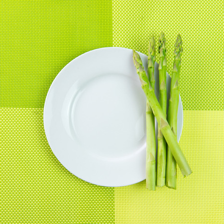 Bundle of fresh asparagus on white plateの写真素材