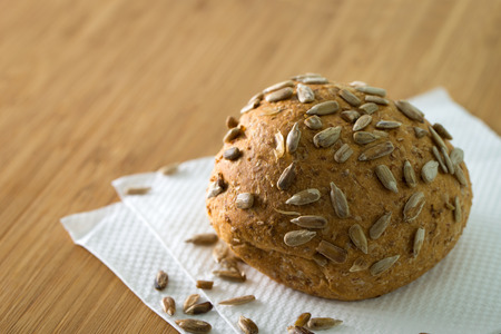 Close up of whole wheat buns with sunflower seeds on chopboard