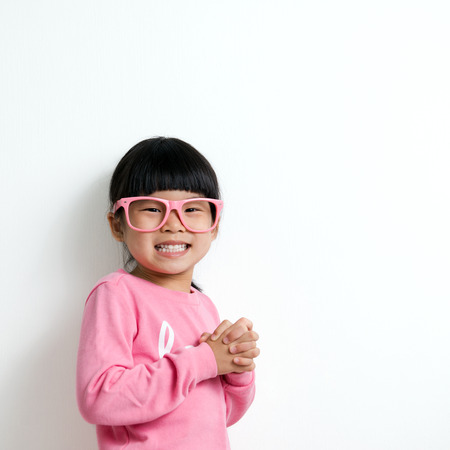 Portrait of happy Asian child wearing pink glassesの写真素材