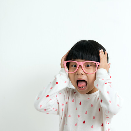 Portrait of happy little Asian girl wearing pink glassesの写真素材