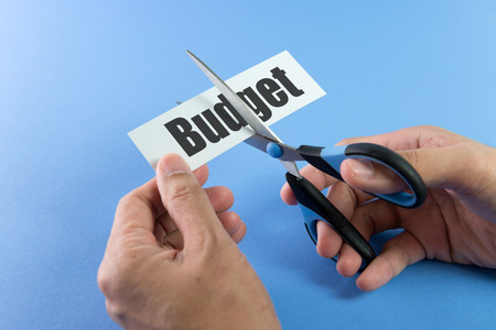 Scissors cutting paper with the word budget on itの写真素材