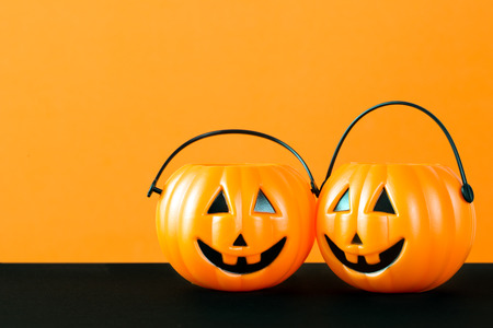 Halloween theme with pumpkin buckets on orange and black backgroundの写真素材