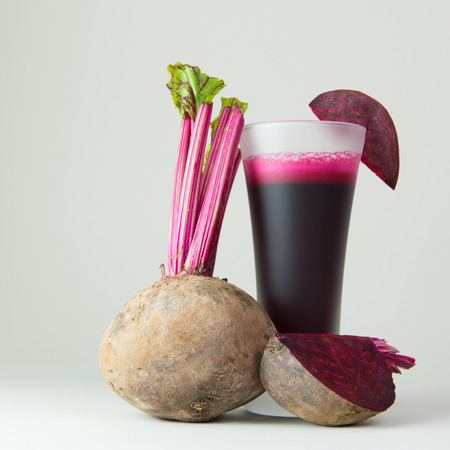Beet root juice and raw beetroot on white background