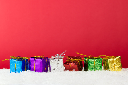 Multicolor Christmas presents on red background, with copy spaceの写真素材