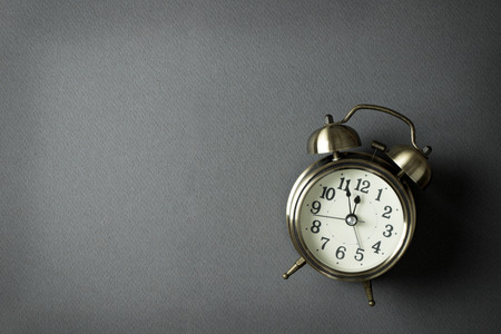 Alarm clock showing almost 12 o clock, with copy spaceの写真素材