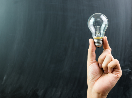 Innovation or creative concept with a hand hold a lightbulbの写真素材