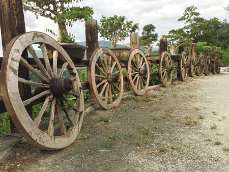 Old wooden carriage wheels along countryside roadの写真素材