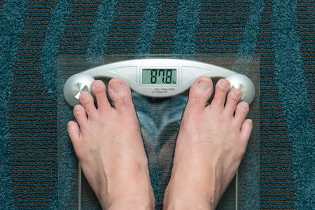 Man feet on weight scale showing 87kg