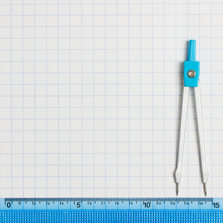 blue compass with ruler on graph paper