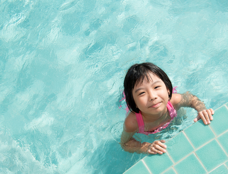 Asian kid in swimming pool on summer vacationの写真素材