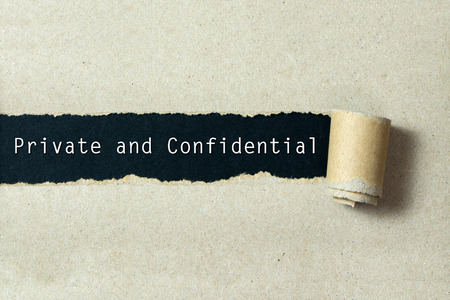 Private and confidential written on torn paper black background Private and confidential written on torn paper black background