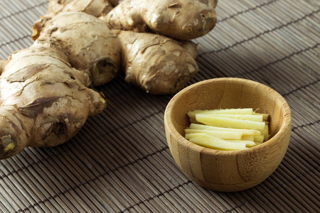 Fresh cut ginger root on brown bamboo mat