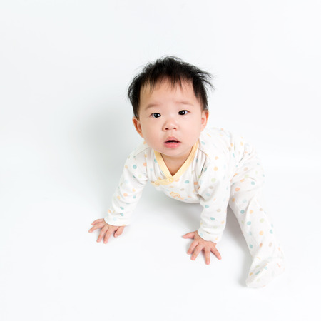 Portrait of Asian baby girl sitting over white backgroundの写真素材