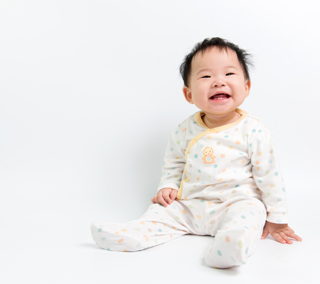 Portrait of Asian baby girl sitting over white backgroundの写真素材