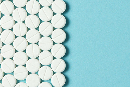 Close up of white round tablets on blue background