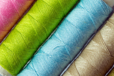 Close up of various colored threads forming background