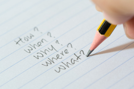 Hand writing questions on paper for brainstorming, uncertainty or decision making conceptの写真素材