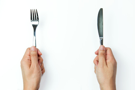 Hand holding fork and knife on white backgroundの写真素材