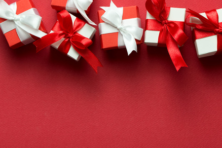 Red and white gift boxes on red background with copy space