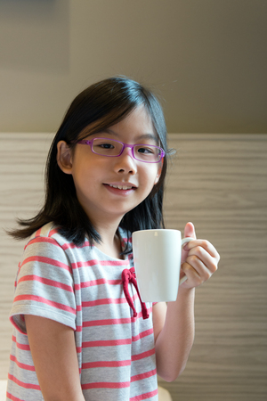 Portrait of Asian child holding a mugの写真素材