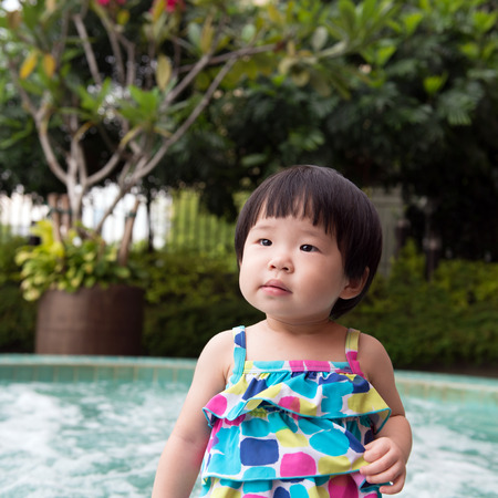 Portrait of little Asian kid at the swimming poolの写真素材