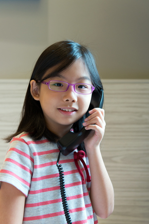 Portrait of Asian little girl speaking on the phoneの写真素材