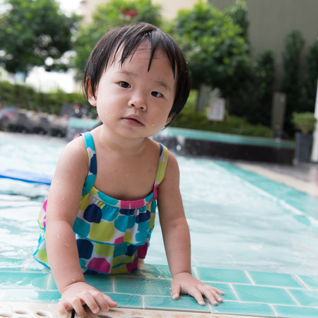 Asian toddler standing the swimming poolの写真素材
