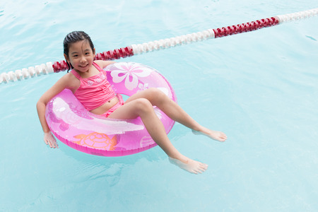 Little Asian girl having fun in the swimming poolの写真素材